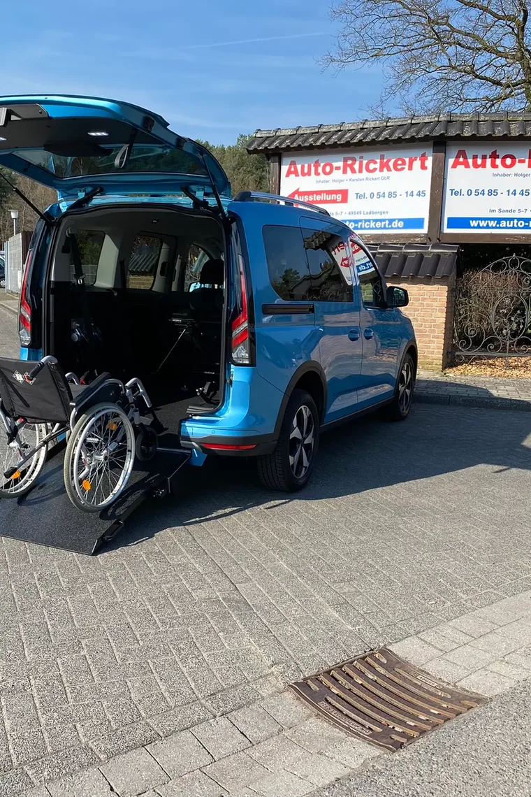 Blauer Ford Tourneo Connect mit heruntergeklappter Rampe, umgeklapptem Sitz und freien Bodenschienen