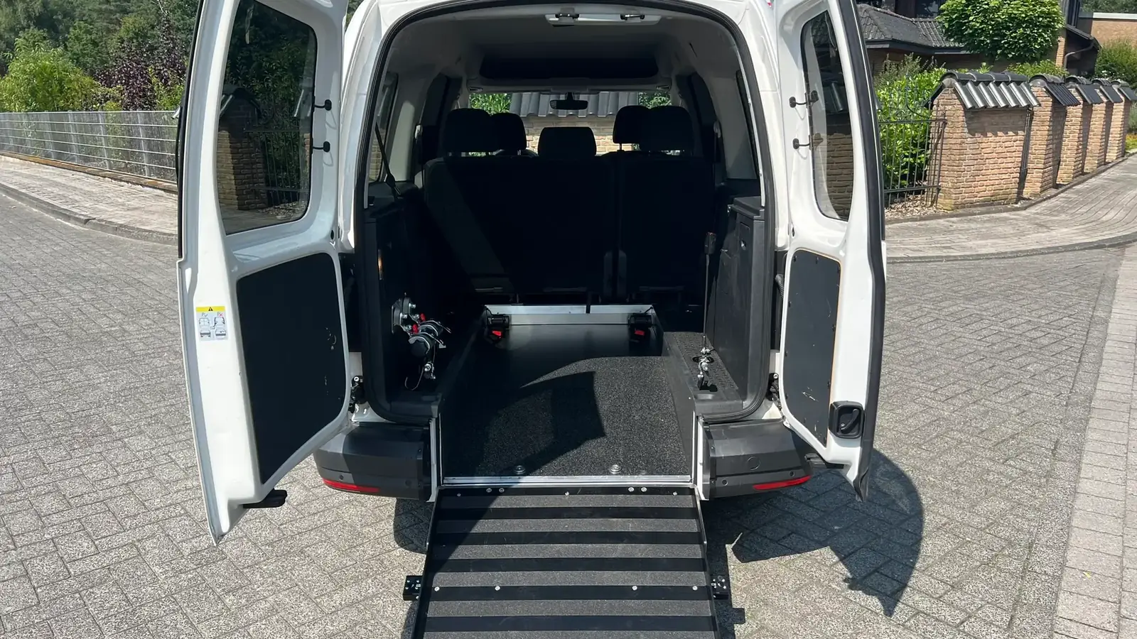 Weißer VW Caddy mit ausgeklappter Rollstuhlrampe